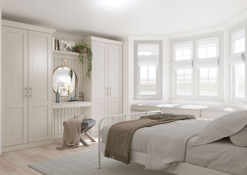 Bright white bedroom with built-in storage and bay window