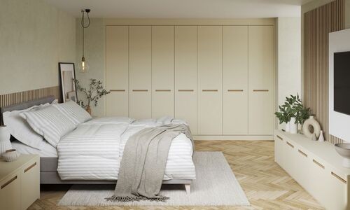 Minimalist bedroom with cream wardrobes and herringbone wood flooring