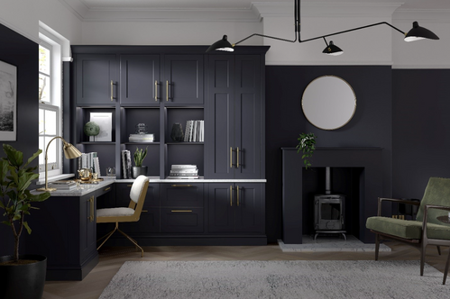 Dark home office with built-in desk and vintage wood stove