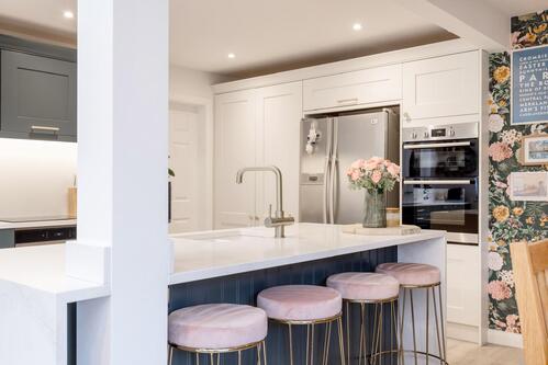 White kitchen with navy accents and pink velvet barstools