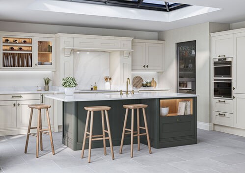 White kitchen with dark island, wooden barstools, and skylight