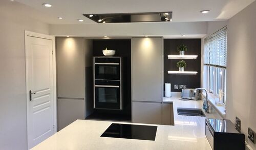 Modern grey kitchen with white countertops and large windows