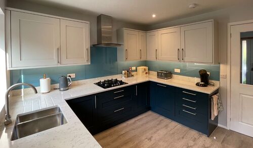 Modern grey kitchen with white countertops and large windows