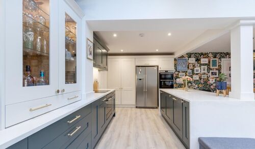 Modern grey kitchen with white countertops and large windows