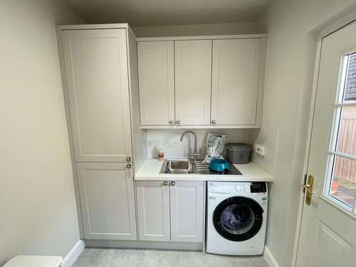 Compact utility space with integrated washer, dryer, and tall cabinets