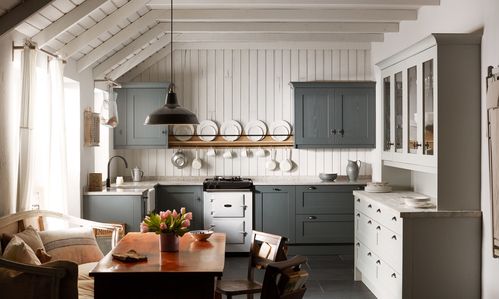 Farmhouse kitchen with gray cabinets, white walls, exposed beams and vintage stove