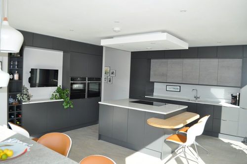 Modern grey kitchen with white island and orange dining chairs