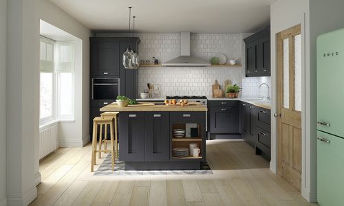 kitchen with charcoal cabinets, white tile backsplash, and wooden island