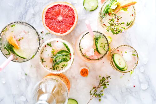 Overhead view of grapefruit, cucumber, and glasses filled with mocktails on a marble surface for Clean Bar PDX.