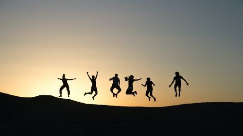 The Clean Life addiction recovery resources, contact page. Image of silhouetted people jumping for joy atop a ridge with the glow of sunset behind them.