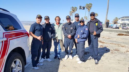 group of men and woman outside on beach