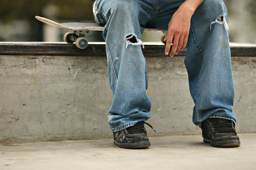 teenage-boy-sitting-on-skateboard