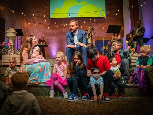 Pastor PJ Aarsvold doing a children's message at church with children gathered around