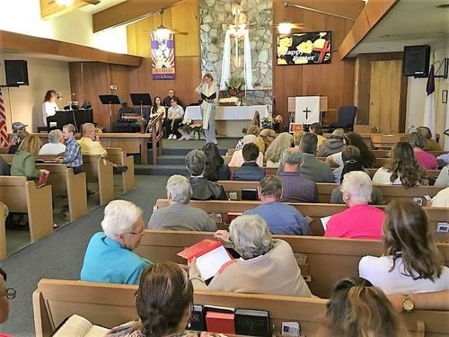 a photo of the church together on Easter Sunday in a brightly decorated sanctuary.