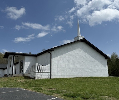 Exterior view of Watts Bar Community Church, showcasing the welcoming entrance and surrounding landscape. The building stands as a place of community and worship.