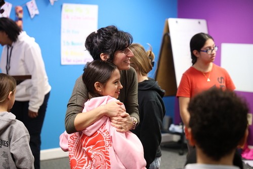 One of our kids workers embraces a child after a worship session!