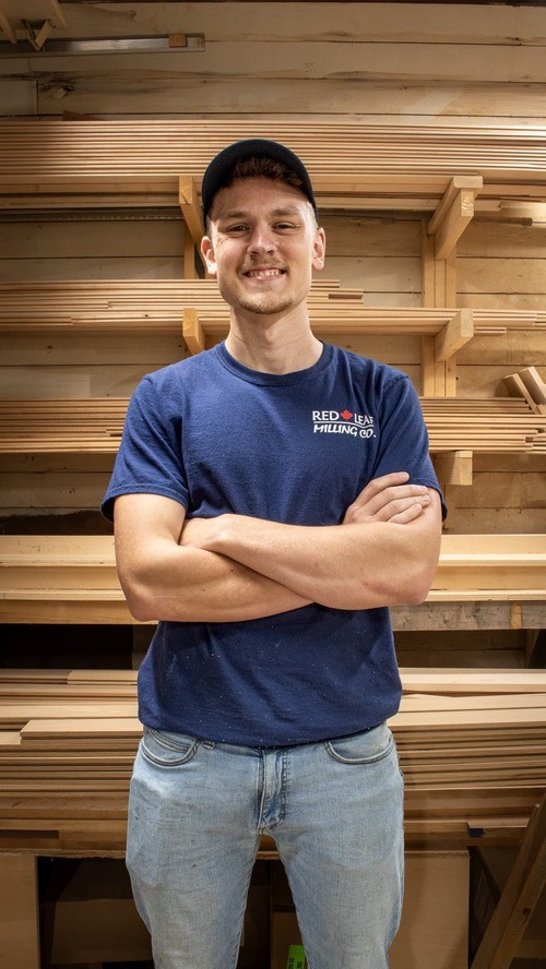 Mason Seiler, millwork shop manager, standing in woodshop