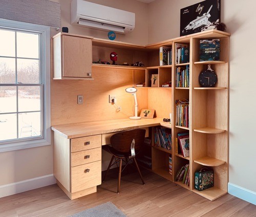 Kitchen with light wood cabinets, stainless steel appliances, a stone island, and pendant lighting, set against a warm brown wall.