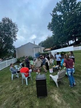 large group of young adults at outdoor firepit