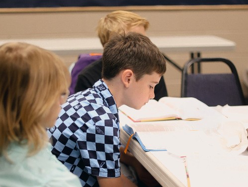 Young boy reading bible during sunday school.