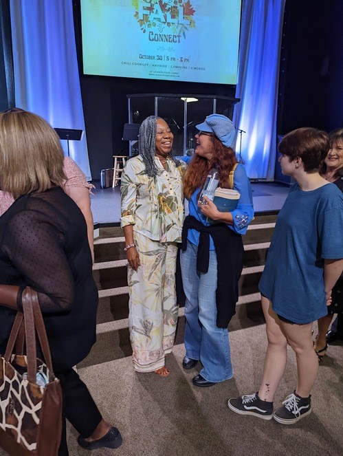 women embrace each other in fellowship at wake cross roads baptist church
