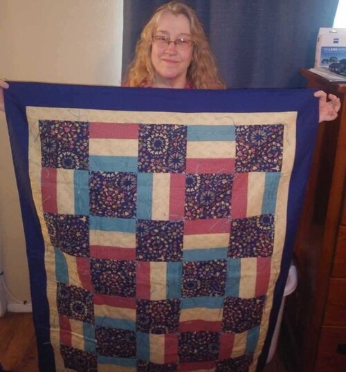 A prayer quilt recipient with her quilt.