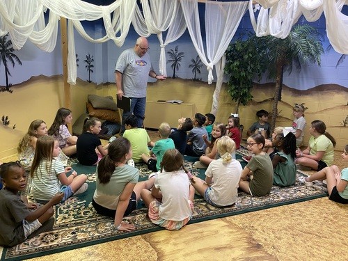 group of school age kids gathering in story time room for a bible lesson