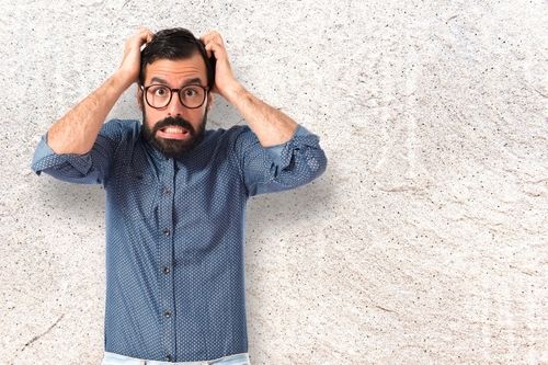 frustrated Young hipster man over textured background
