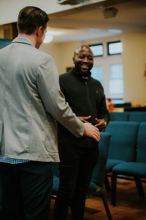 Two men greeting each other at Hope City Church in Providence