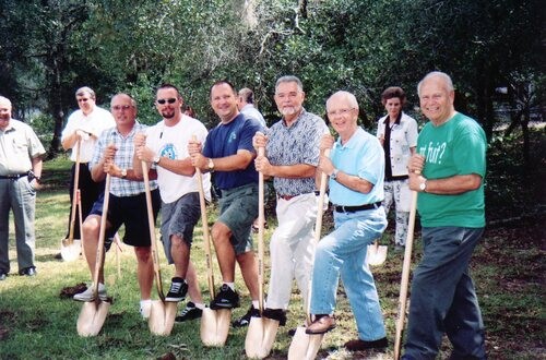 Men breaking ground with symbolic gold shovels.