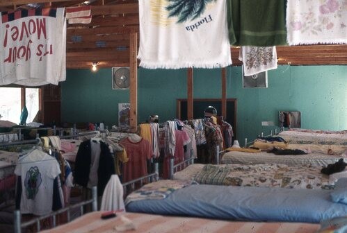 Old bunkbeds with hanging clothes.