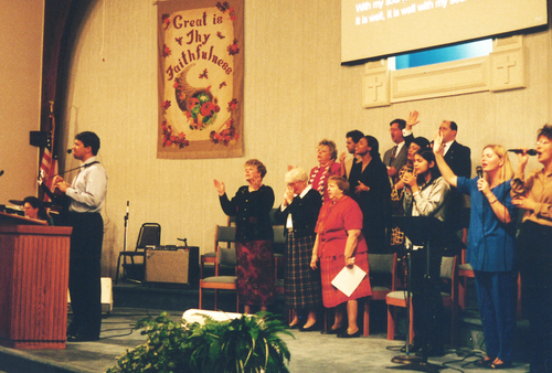 Choir singing with arms raised