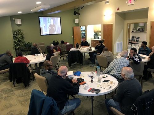 Group of men watching a video presentation