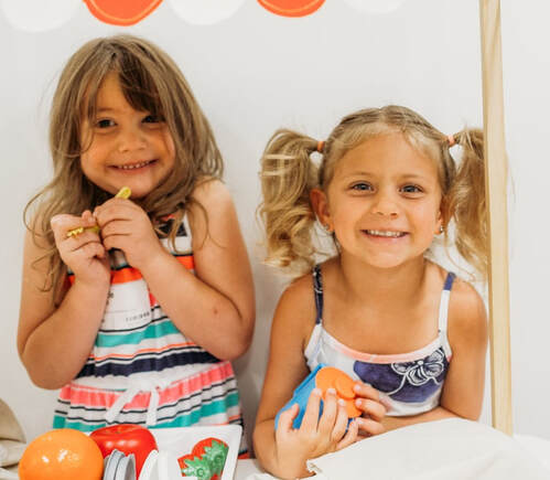 Two children smiling to eachother at Crossroads