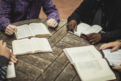 photo of men around a table with bibles