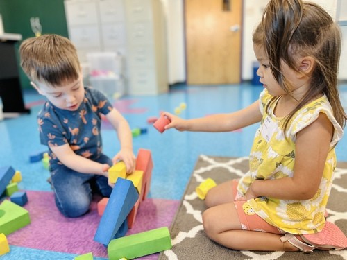 Two young children building with colorful blocks during playtime in an RCC Kids classroom.