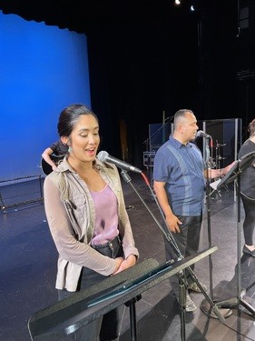 Worship team members at Restoration City Church rehearsing on stage before Sunday service.