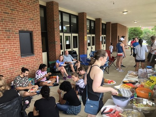 Restoration City Church members enjoying food and fellowship during a community meal outside the church.