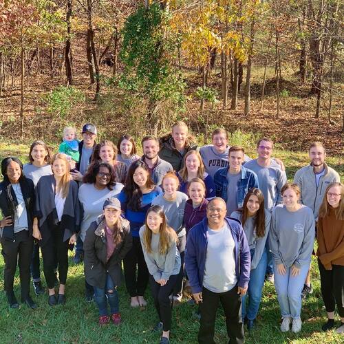 Restoration City Church community group smiling together during a weekend retreat in the woods.