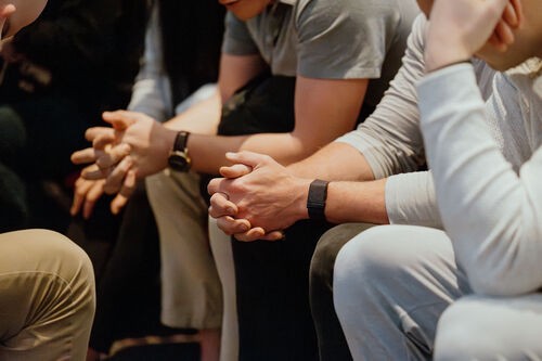 Two people's hands folded in prayer