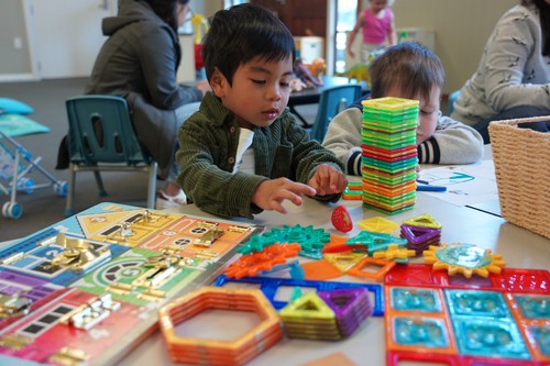 Children playing with colorful building toys and puzzles during a kids’ program at church.