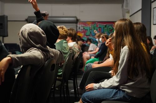 kids sitting in chairs facing forward in youth ministry