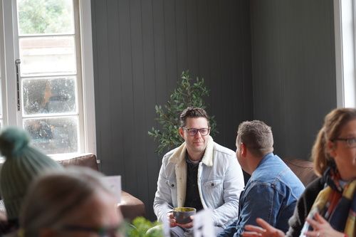 People having a conversation and coffee together in a relaxed church setting.