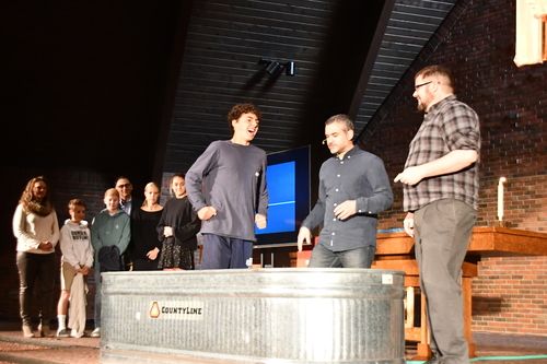 Teenage boy being baptized in a tank in the Worship Center