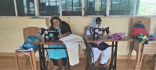 Two Indian women working at sewing machines