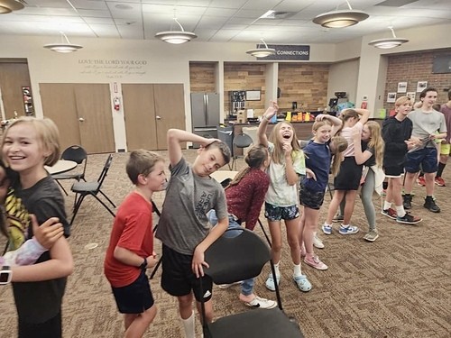 Group of middle school kids laughing together and playing a game