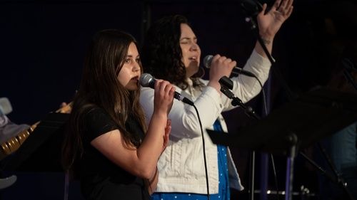 Women singing in the worship center