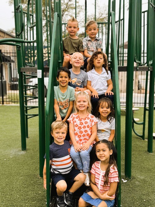 MCA students are lined up on the stairs to the playground, smiling for a picture.