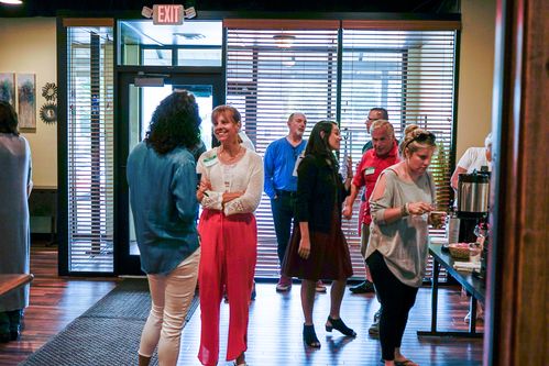 Picture of several people talking in the lobby, getting coffee and socializing before service starts.