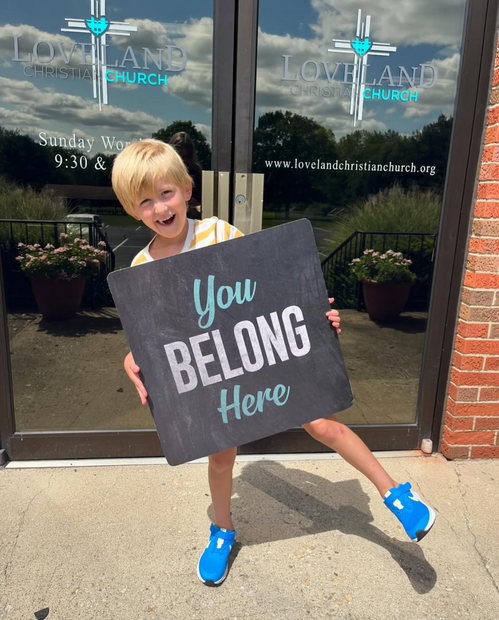 child holding sign reading,